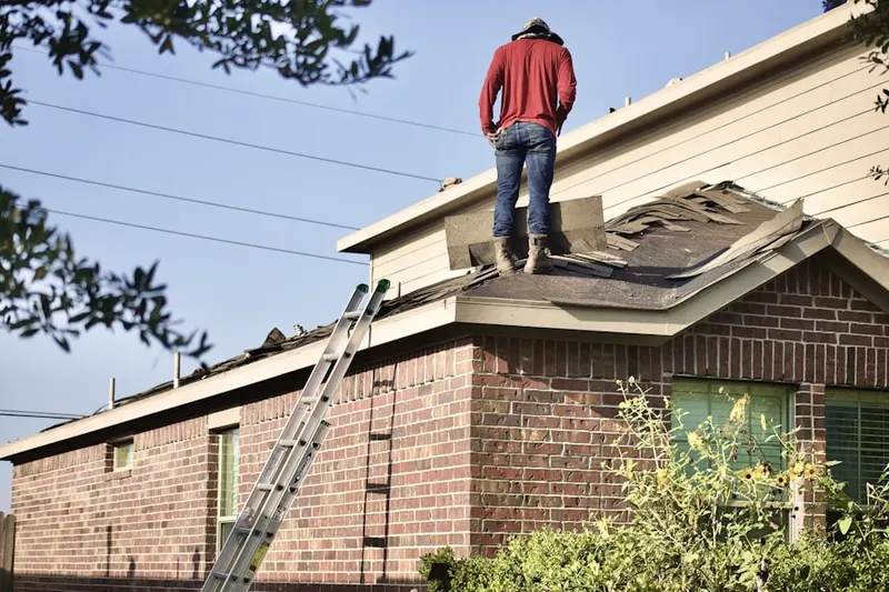 Professional roofer working on a residential roof in Rochester